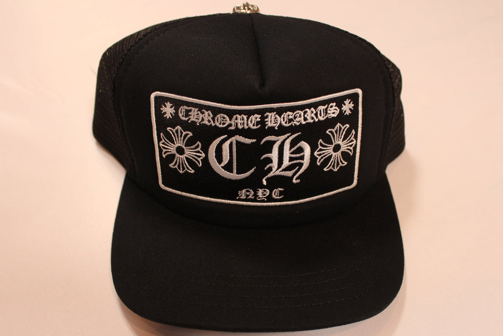 Black cap with 'Chrome Hearts' logo on a beige background