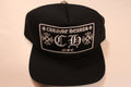 Black cap with 'Chrome Hearts' logo on a beige background